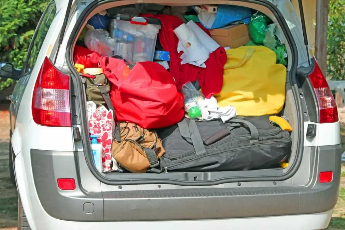 A Trunk overloaded with bags and dorm essentials, ready to be taken to a storage unit. 